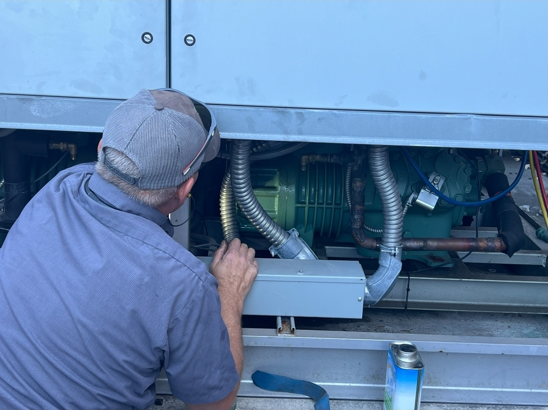 Technician performing detailed maintenance on commercial equipment