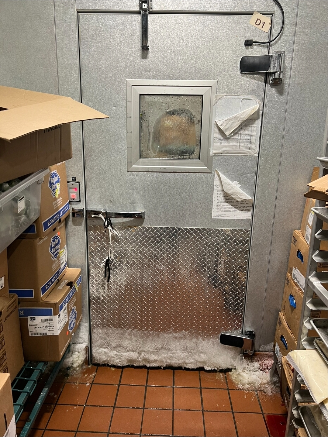 Commercial freezer door with severe ice buildup and frost damage