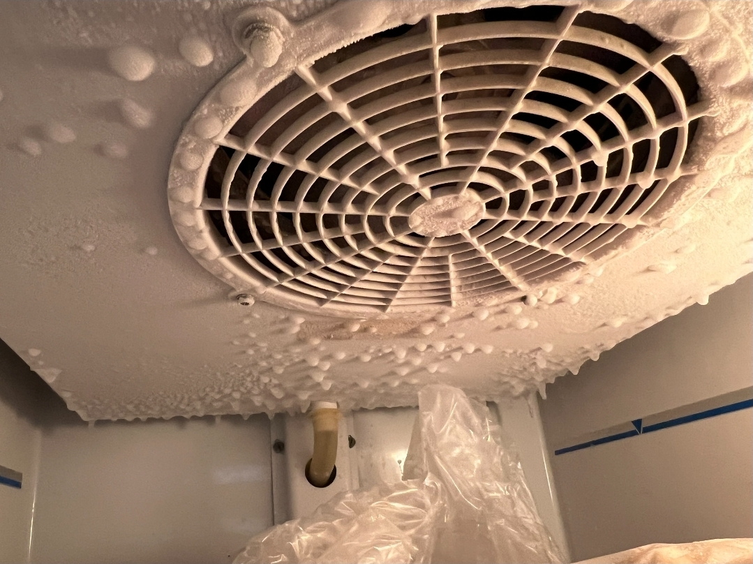 Evaporator fan completely covered in ice showing system malfunction