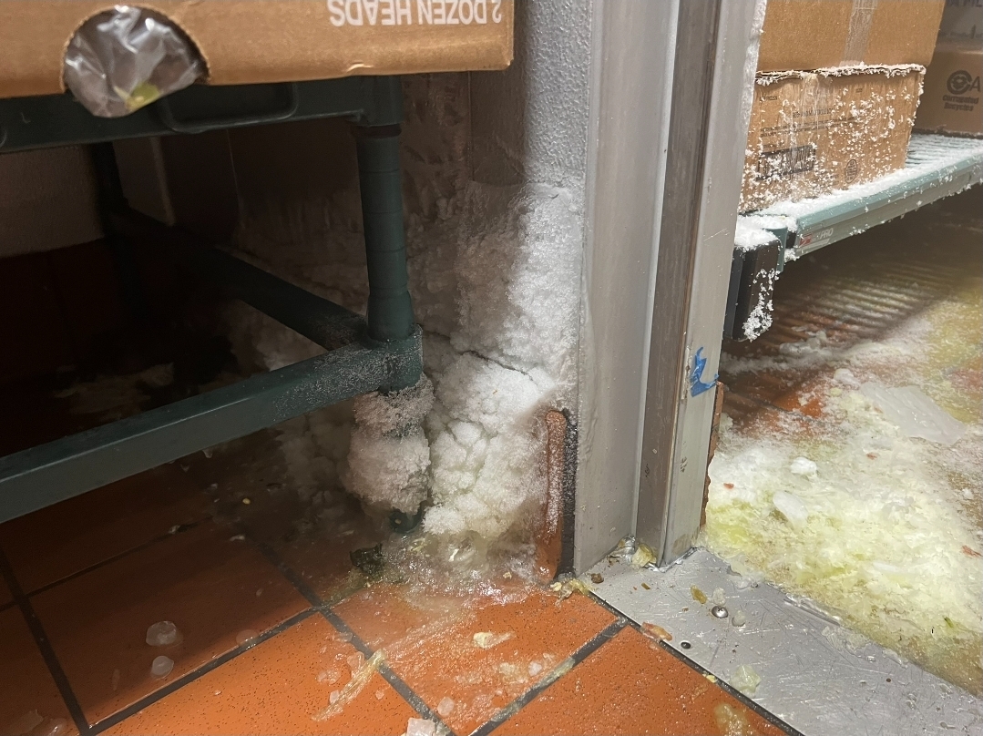 Severe ice buildup damage around walk-in cooler door frame